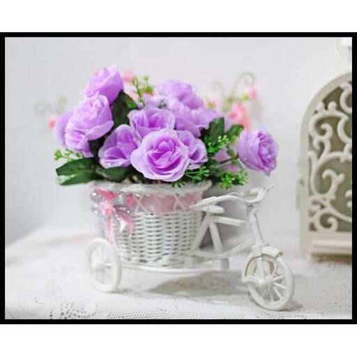 a basket of purple roses in a vintage metal basket.