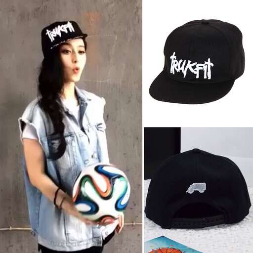 a woman holding a ball and a hat.