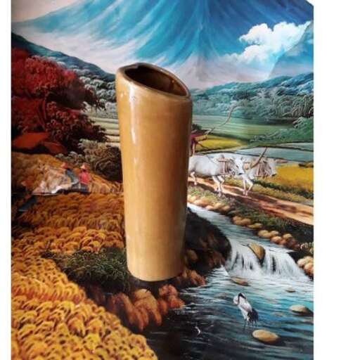 a vase with a view of a mountain and a waterfall.