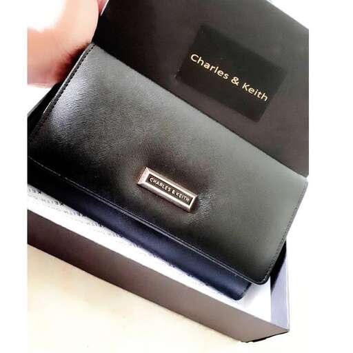 a black leather wallet with a gold logo on the front.