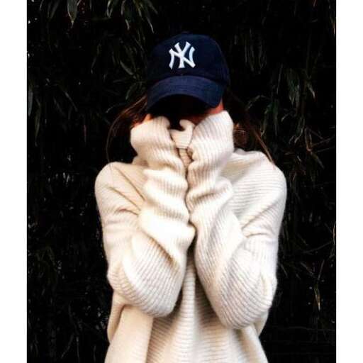 a girl in a white sweater and hat is wearing a hat.