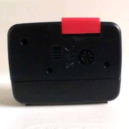 a small black cell phone with a red square on it.