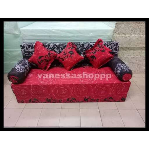 a red couch with black and white pillows on it.
