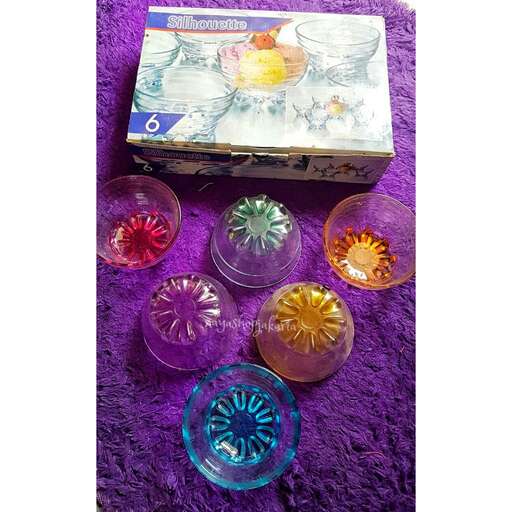 a box of colorful glassware on a purple blanket.
