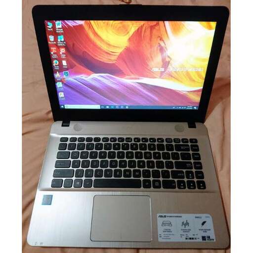 a laptop computer sitting on top of a blanket.