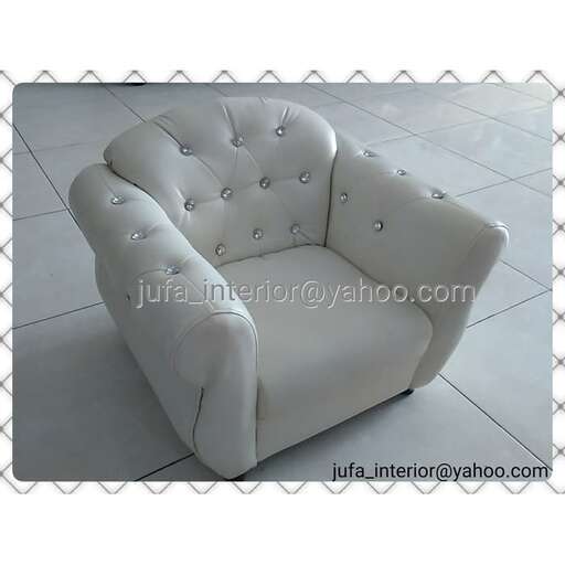 a white leather chair with a silver metal frame.