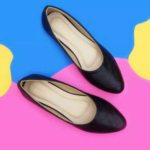 a pair of black flat shoes with a pink background