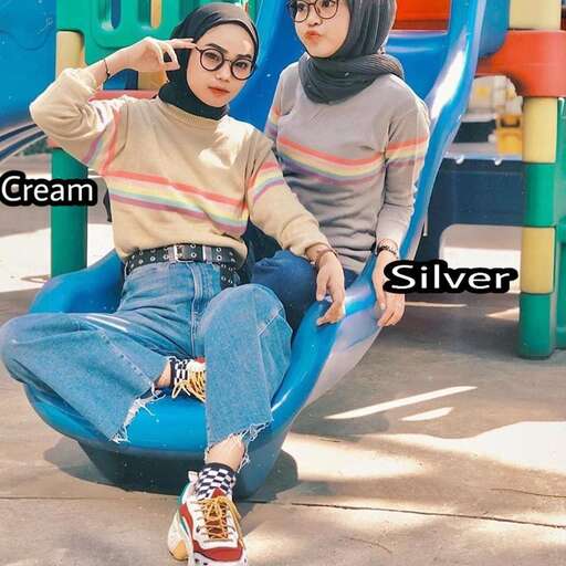 a woman in glasses and a striped sweater sitting on a slide.