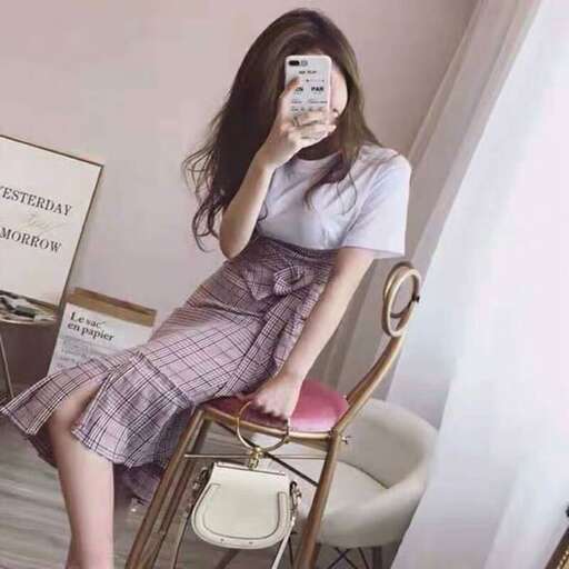 a woman sitting in a chair holding a cell phone.