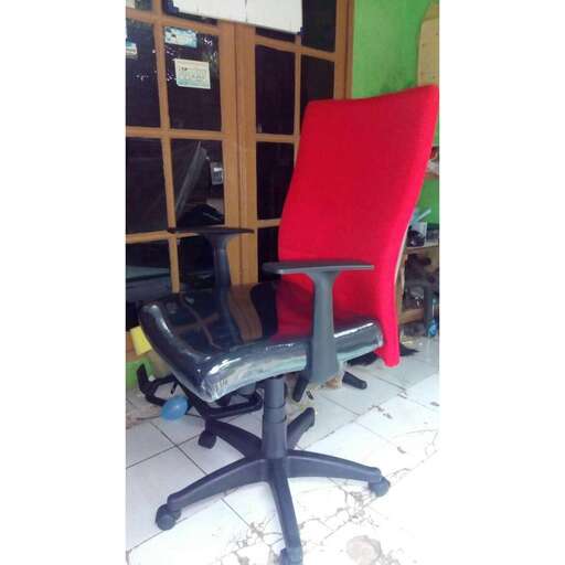 a red office chair sitting in front of a window.