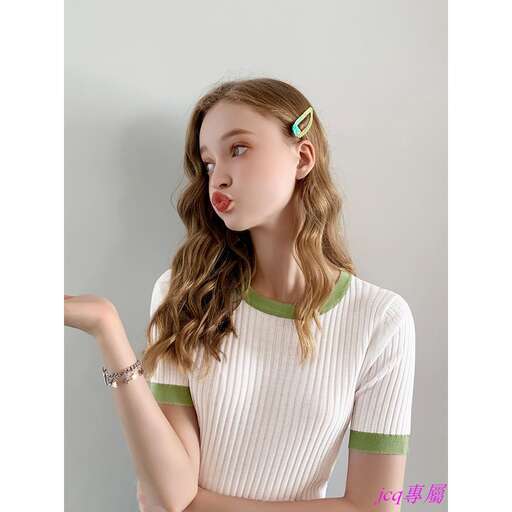 a model wearing a green and white striped shirt with a bow in the hair.