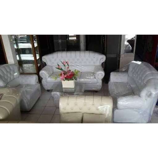 a living room with white leather chairs and a coffee table.
