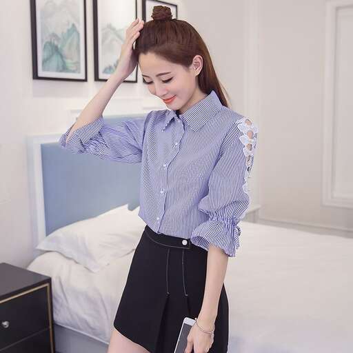 a woman in a blue shirt and black shorts standing in a room.