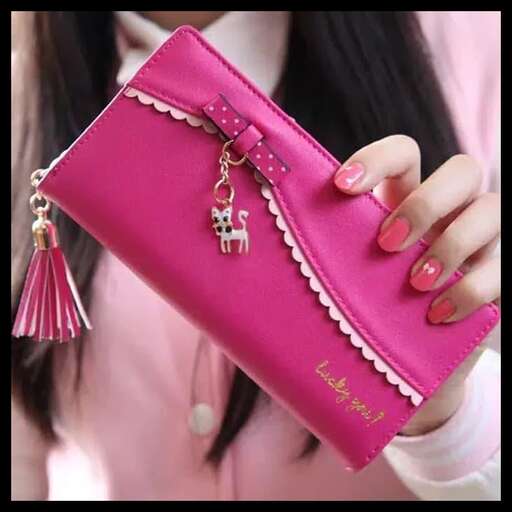 a pink purse with a gold key chain and earrings.