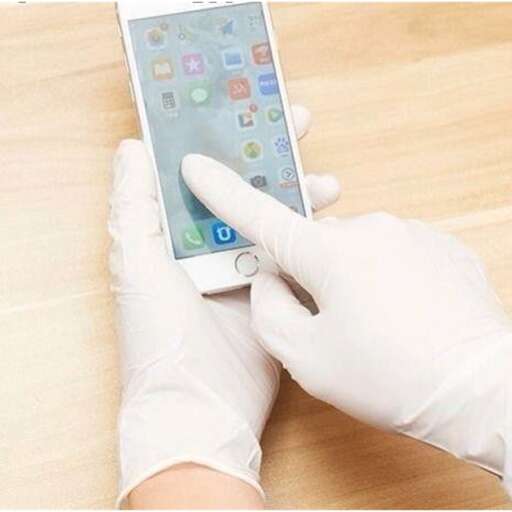 a person wearing a glove holding a cell phone.