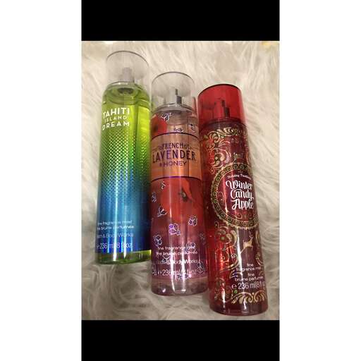 a bottle of perfumes in a row, with a bottle of wine in the middle.