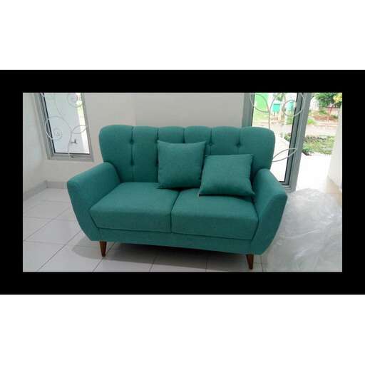 a green couch sitting in a living room.