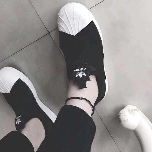 a woman wearing black and white shoes and socks.