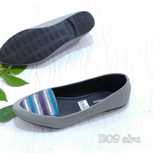 a pair of flat shoes with a green plant.
