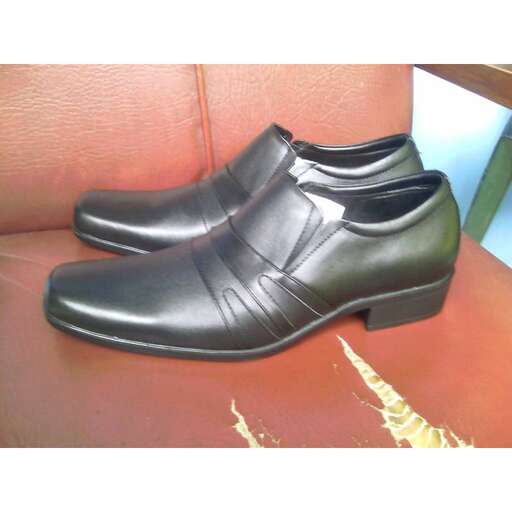 a pair of black leather shoes on a red seat.