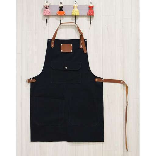 a black apron with a brown leather strap.