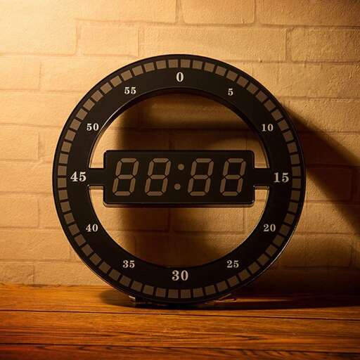 a clock that is on a table with a wall behind it.
