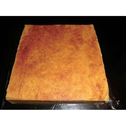 a square piece of cake on a black background.