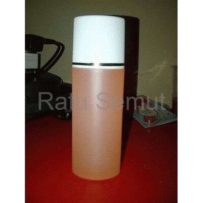 a bottle of orange liquid sitting on a table.