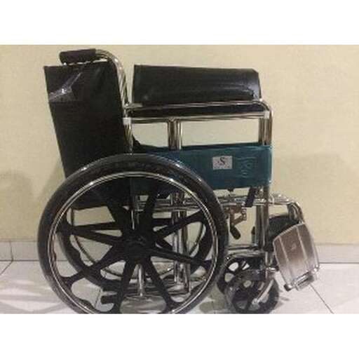 a wheelchair sitting on a tiled floor next to a suitcase.