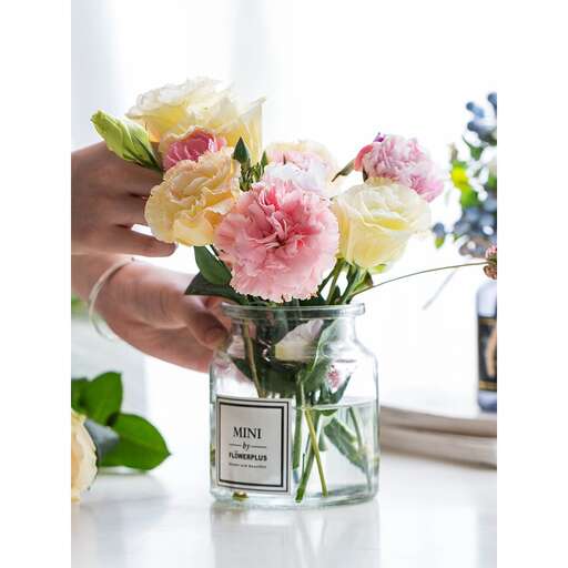 a person holding a vase filled with flowers.