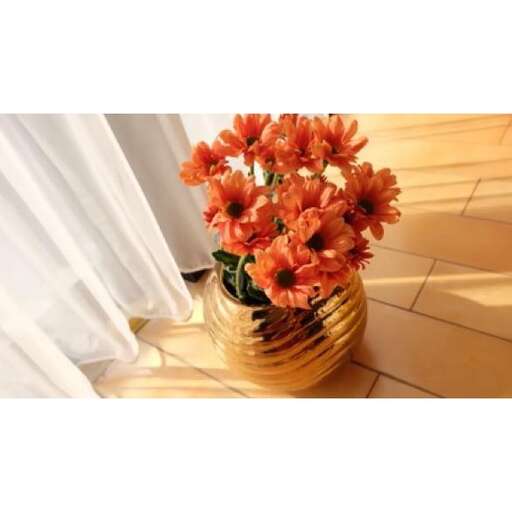 a vase with flowers on a wooden floor.