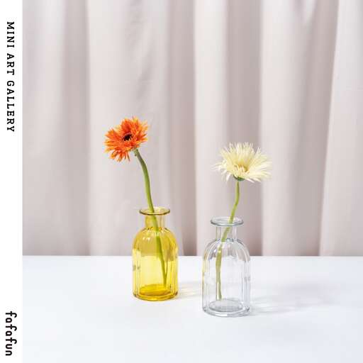 two vases with flowers in them on a table.