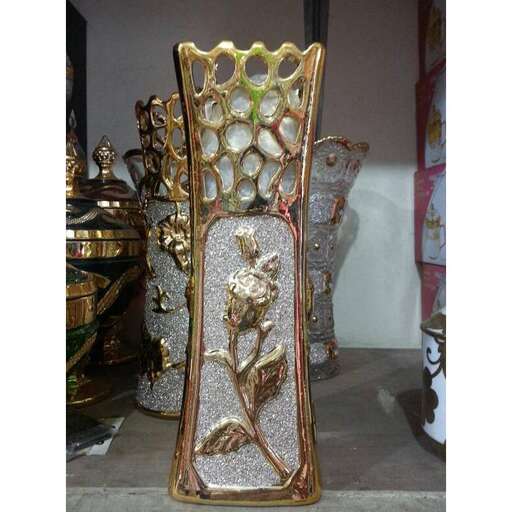 a vase with a woman on it is standing on a table.