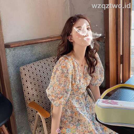 a woman in a dress is smoking a cigarette.