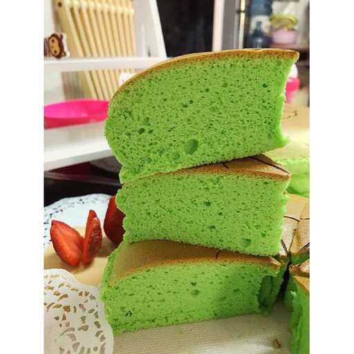 a green cake sitting on top of a table.
