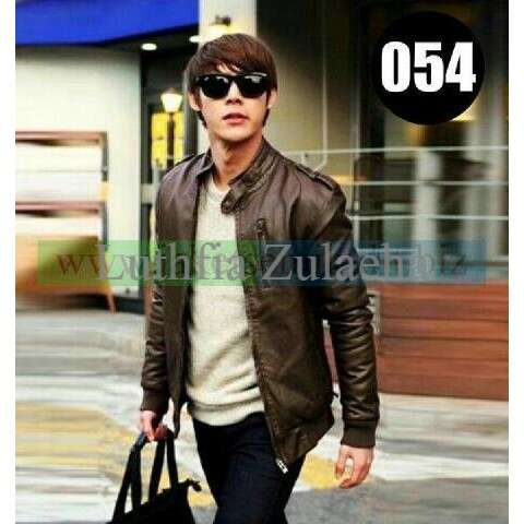 a man in a leather jacket carrying a bag.