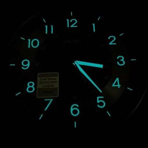 a clock with blue numbers and a green light.