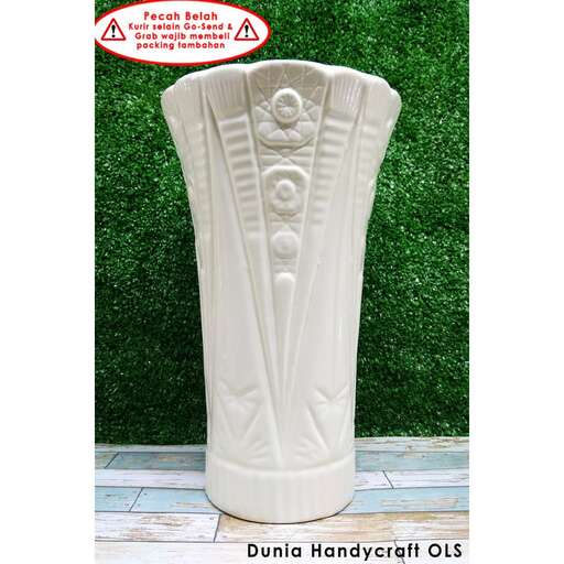 a large white vase sitting on a green wall.