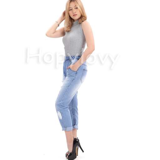 a woman in a grey tank top and jeans