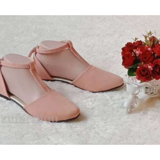 a pair of pink shoes sitting on a white rug.