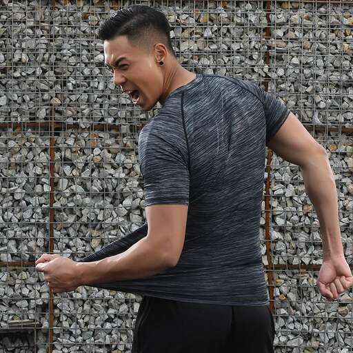 a man in a grey shirt is smiling and laughing.