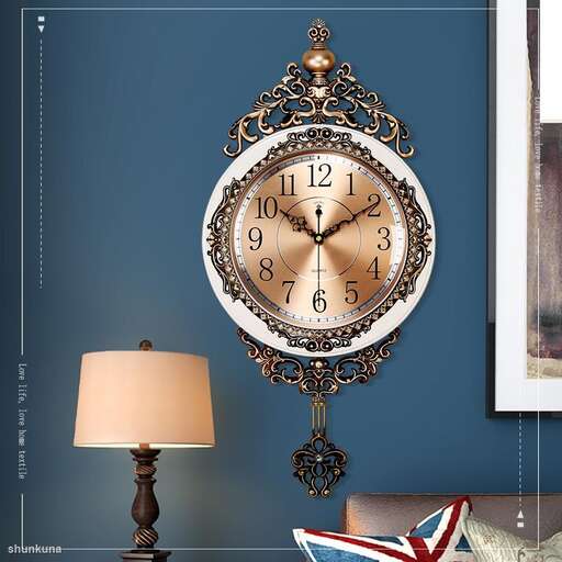 a clock with a decorative frame and a lamp on a table.