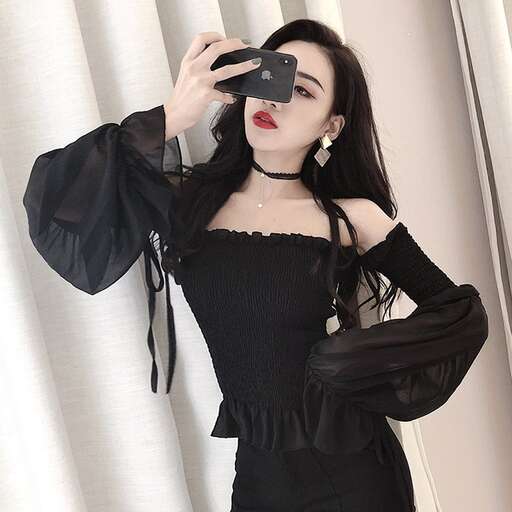a woman in a black dress taking a selfie.