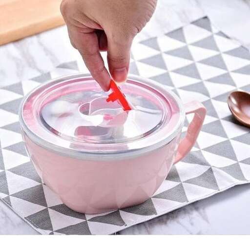 a person putting a red plastic spoon into a pink cup.