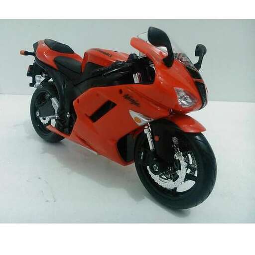 a red motorcycle parked on a white surface.