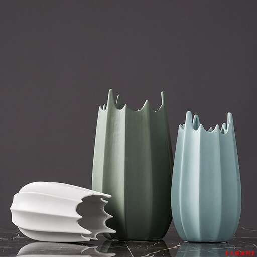 a white vase with a white vase on a table.