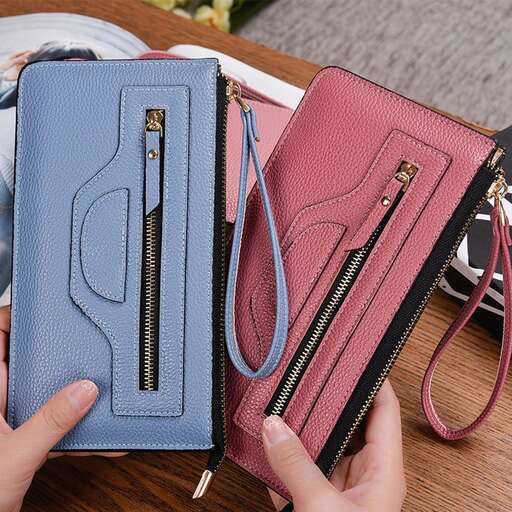 a person holding a wallet and a wallet on a table.