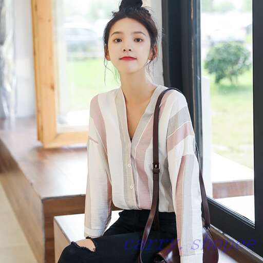 a young woman sitting on a bench in front of a window.