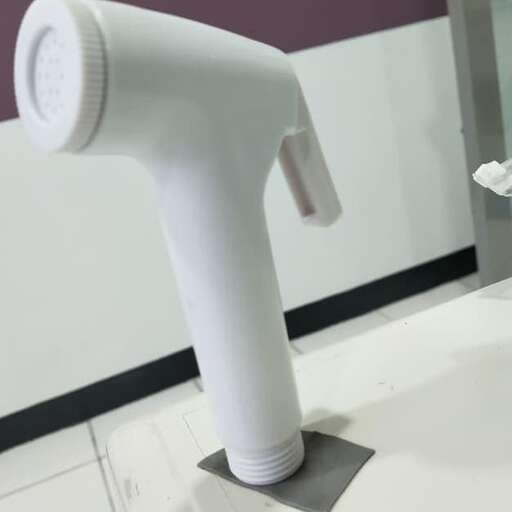 a white plastic blow dryer is placed on a table.