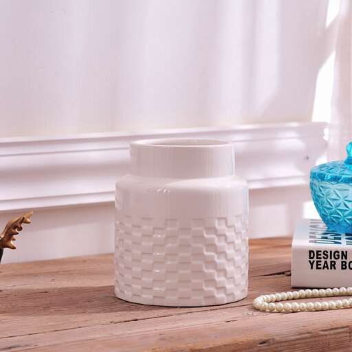a white and blue vase and a blue vase on a table.